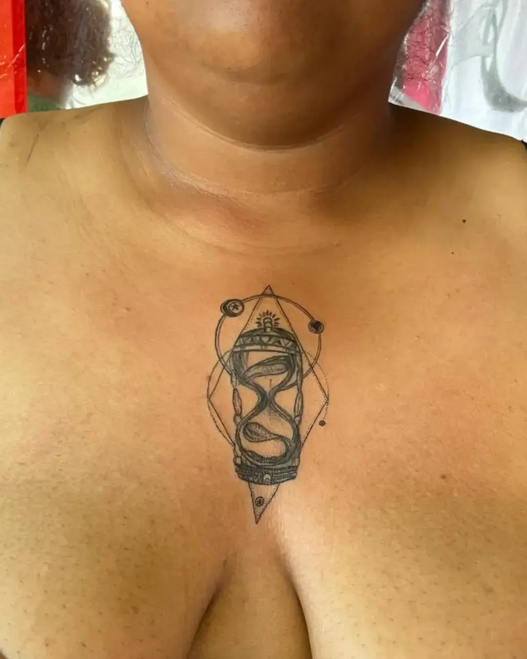 Tatouage sablier ornemental avec serpent et symboles géométriques – représentation du temps, de la vie et de la transformation, réalisé par Magic Ink à Fribourg.