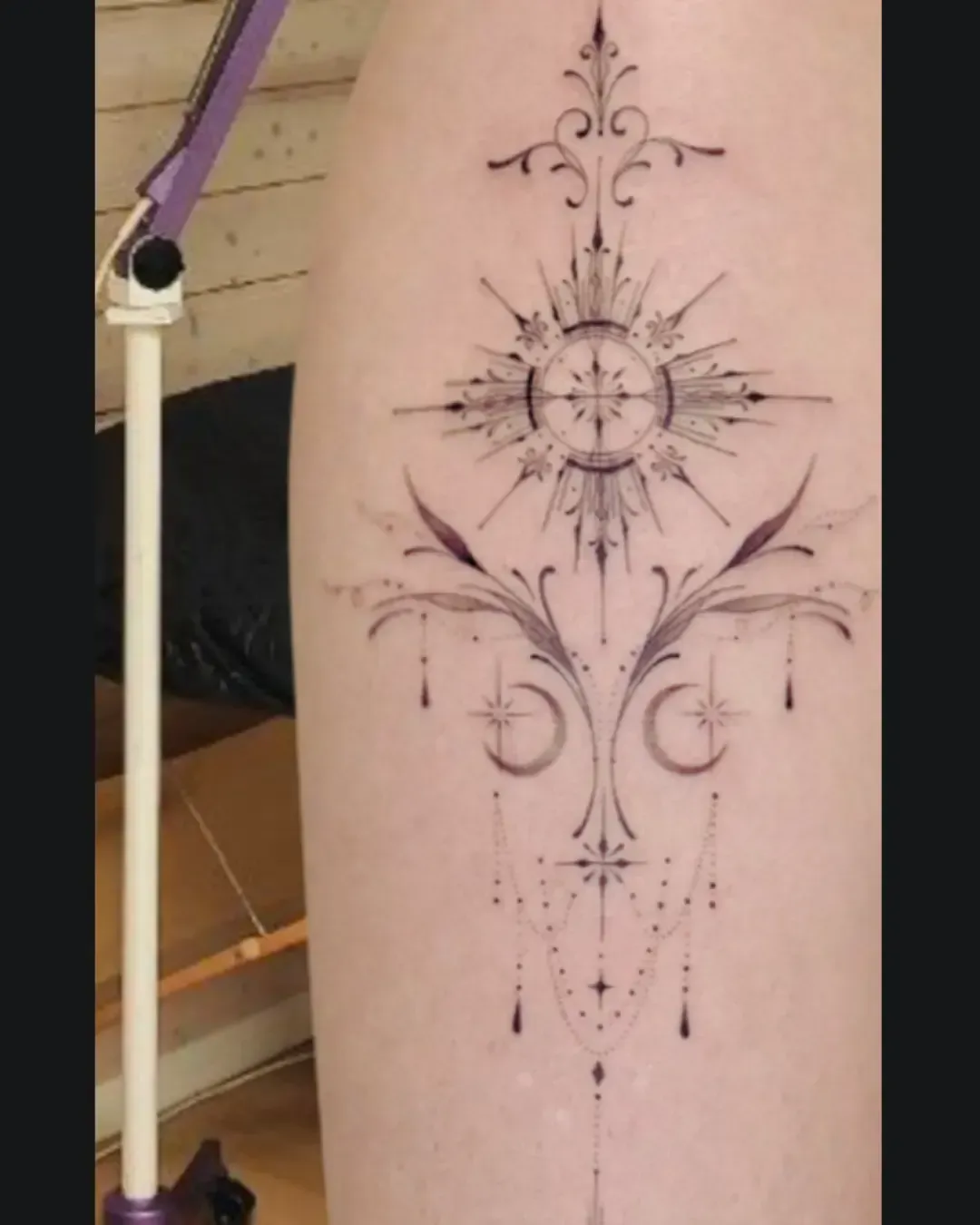 Tatouage ornemental géométrique avec soleil, croissant de lune et motifs délicats en dotwork – symbole d’équilibre cosmique et de spiritualité, réalisé par Magic Ink à Fribourg.