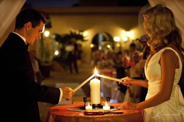Bride and groom lighting a unity candle during a personalized wedding ceremony.