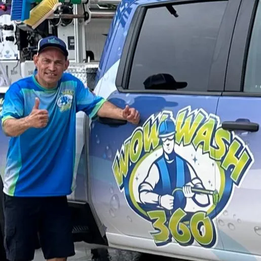 Man giving a thumbs up next to a vehicle with the Wow Wash 360 logo, representing the professional exterior cleaning team committed to quality service.