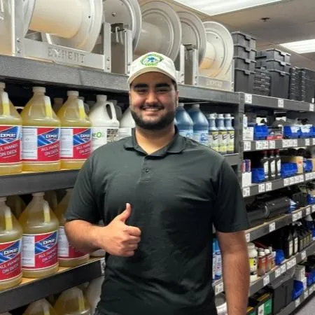 Employee at Wow Wash 360 smiling and giving a thumbs-up in front of cleaning supplies, showcasing the commitment to quality service in exterior cleaning.