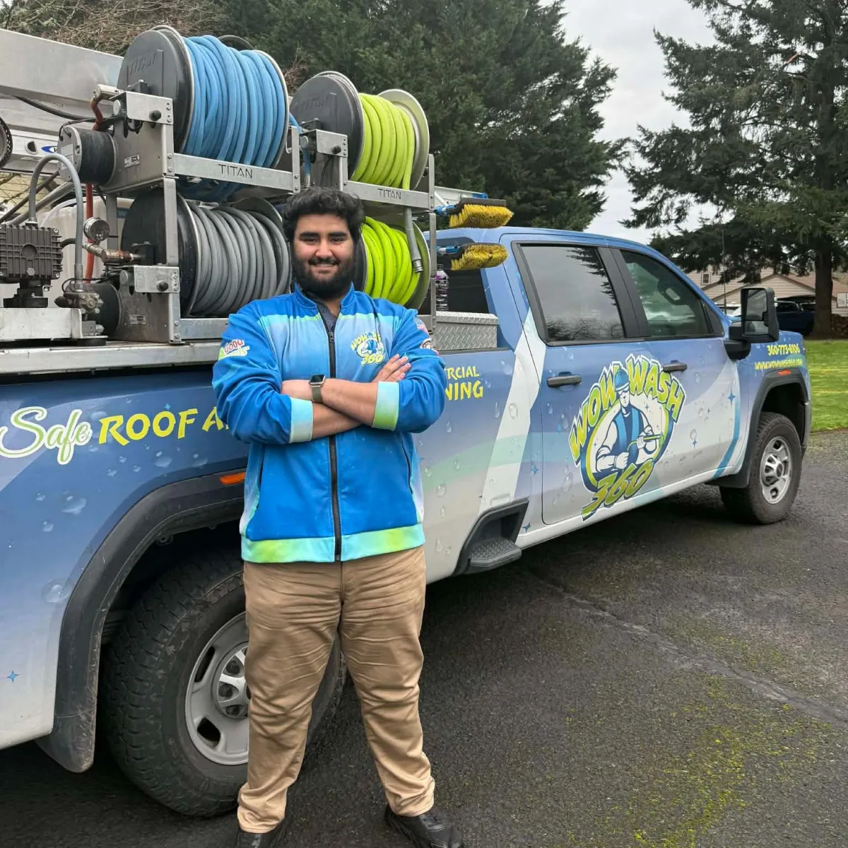 Employee at Wow Wash 360 smiling and giving a thumbs-up in front of cleaning supplies, showcasing the commitment to quality service in exterior cleaning.