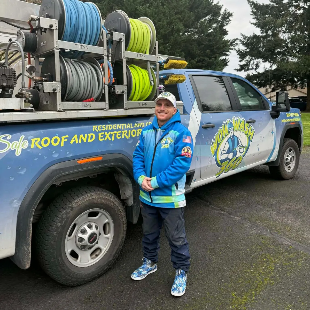 Employee at Wow Wash 360 smiling and giving a thumbs-up in front of cleaning supplies, showcasing the commitment to quality service in exterior cleaning.