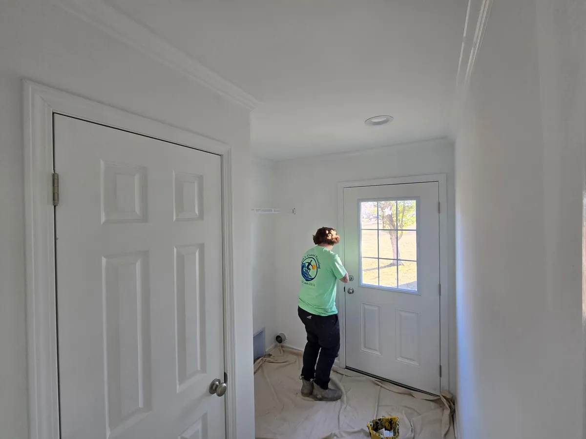 Painter working in an interior hallway