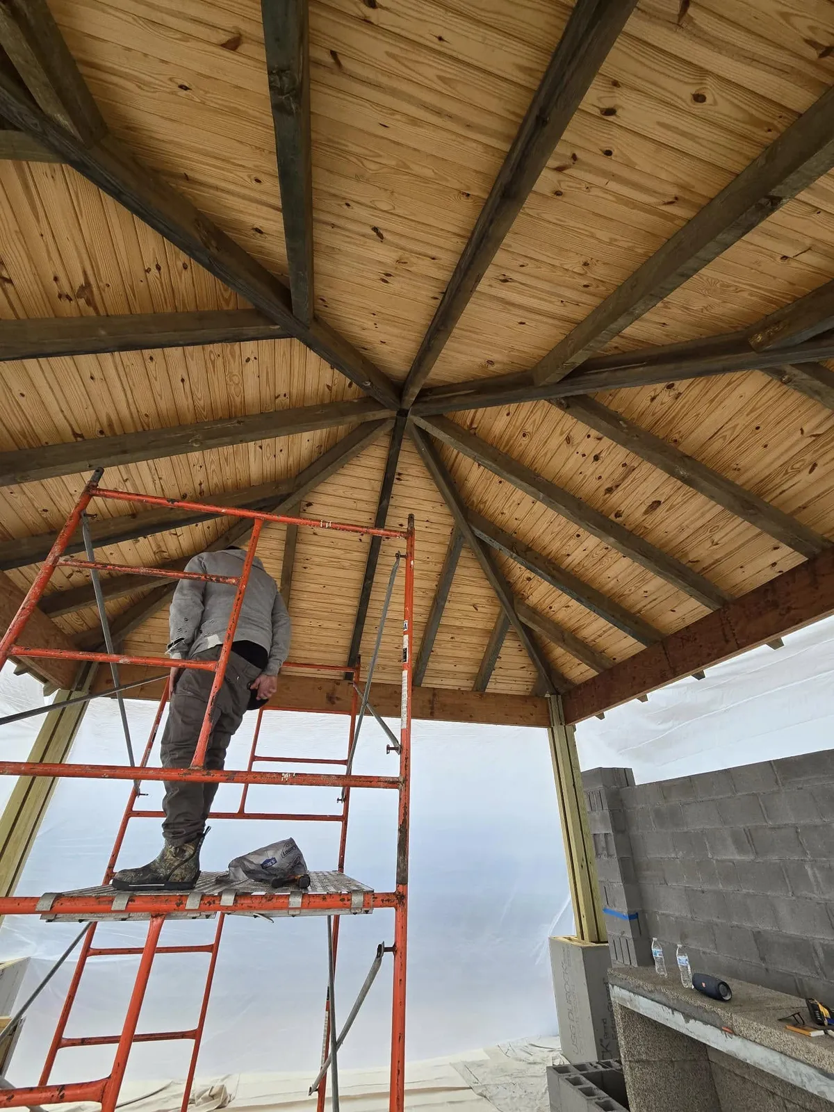 Painter working on a wood gazebo ceiling