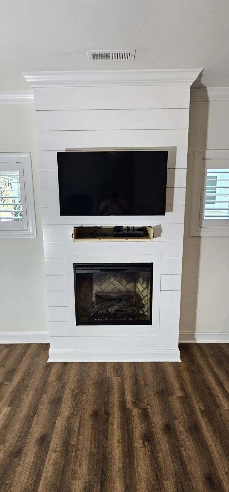 Living room with fresh paint around a wall mounted TV and fireplace