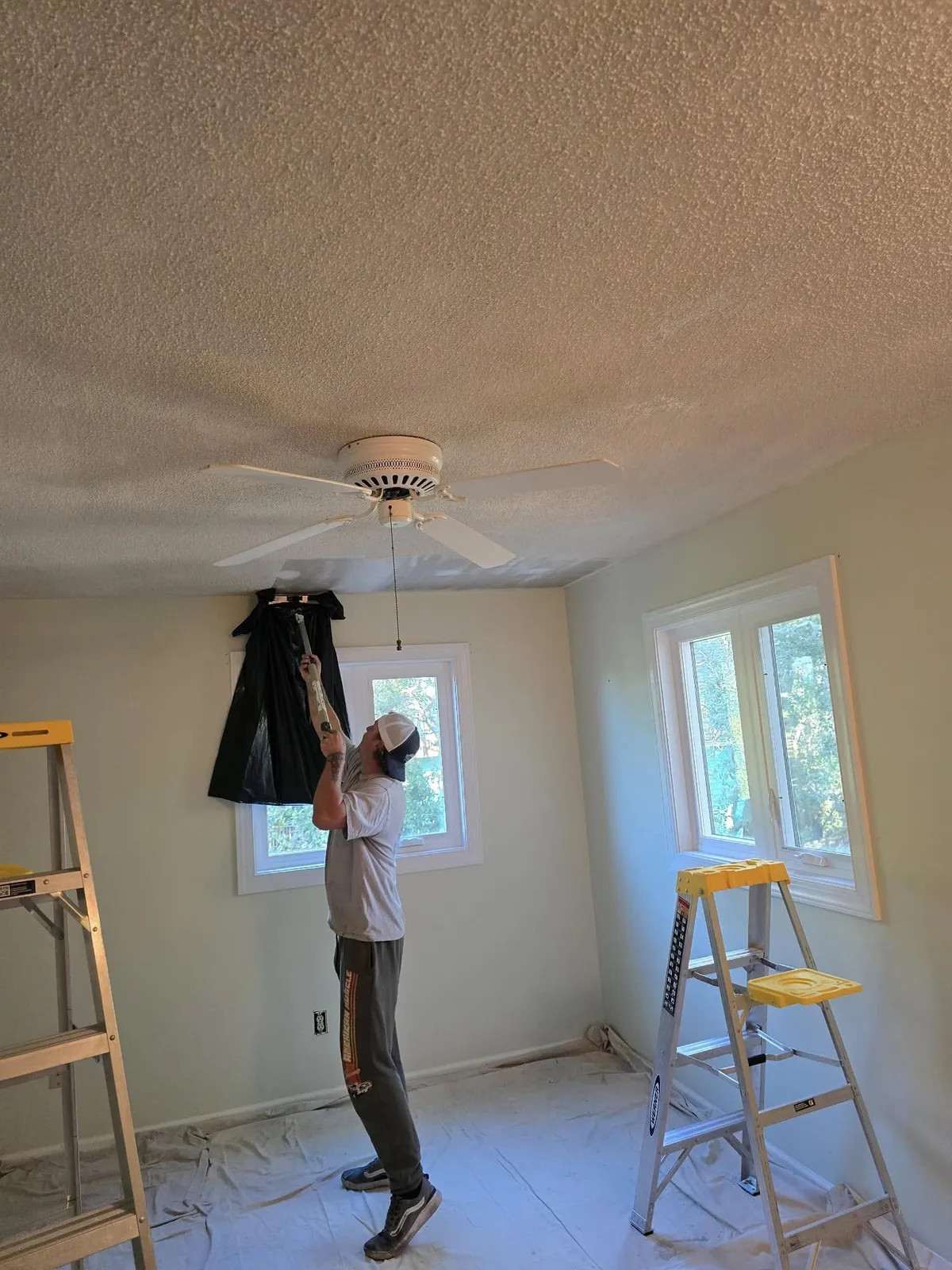 Painter working on a ceiling in a bright room