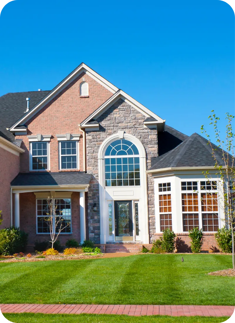 Beautiful two-story brick and stucco home with large windows and landscaped yard, showcasing the types of properties served by AAA Complete Home Inspections in Nashville and Middle Tennessee.