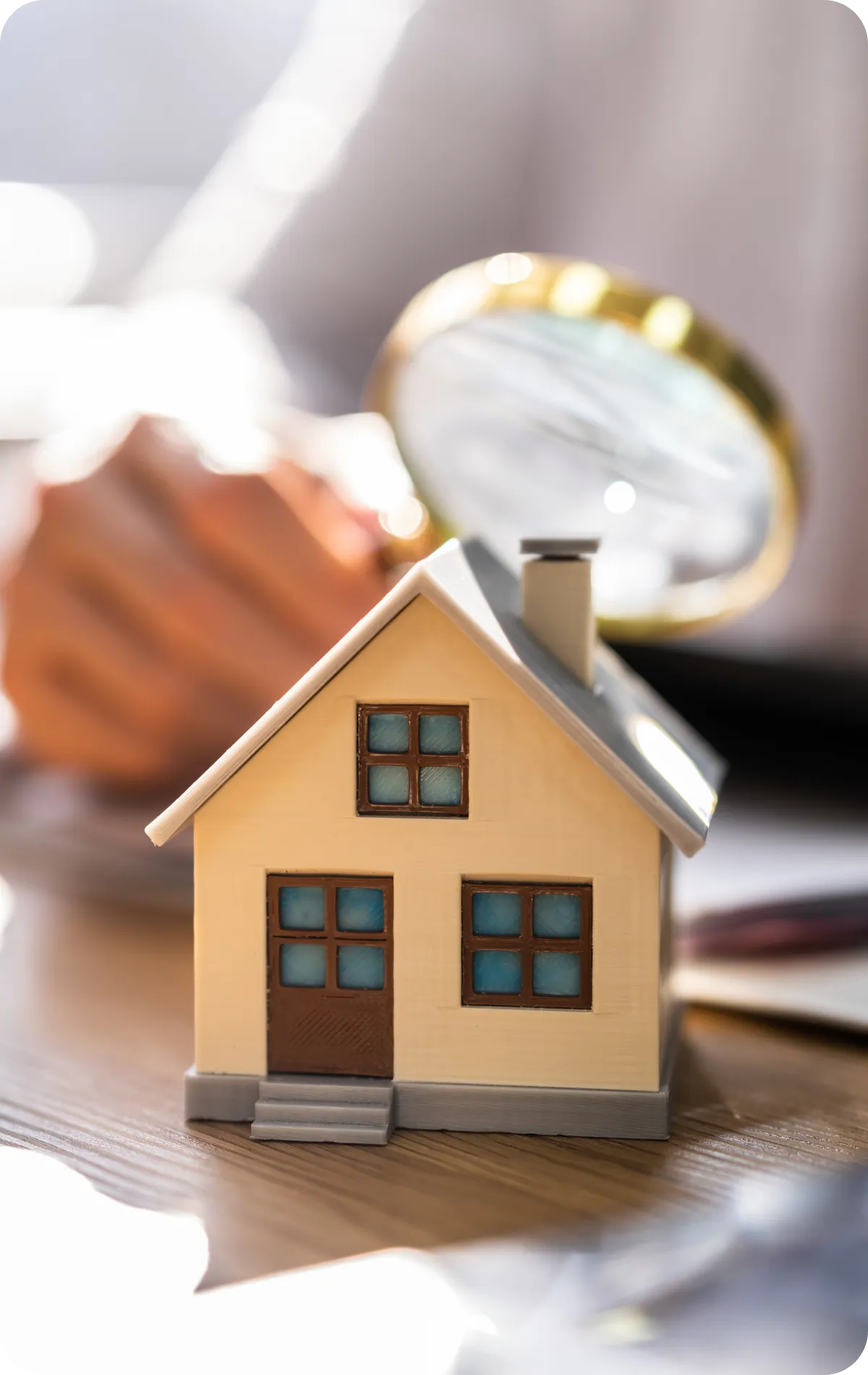 Miniature house being examined with a magnifying glass, symbolizing detailed 1-year warranty home inspections that uncover construction defects for homeowners in Nashville and Middle Tennessee.