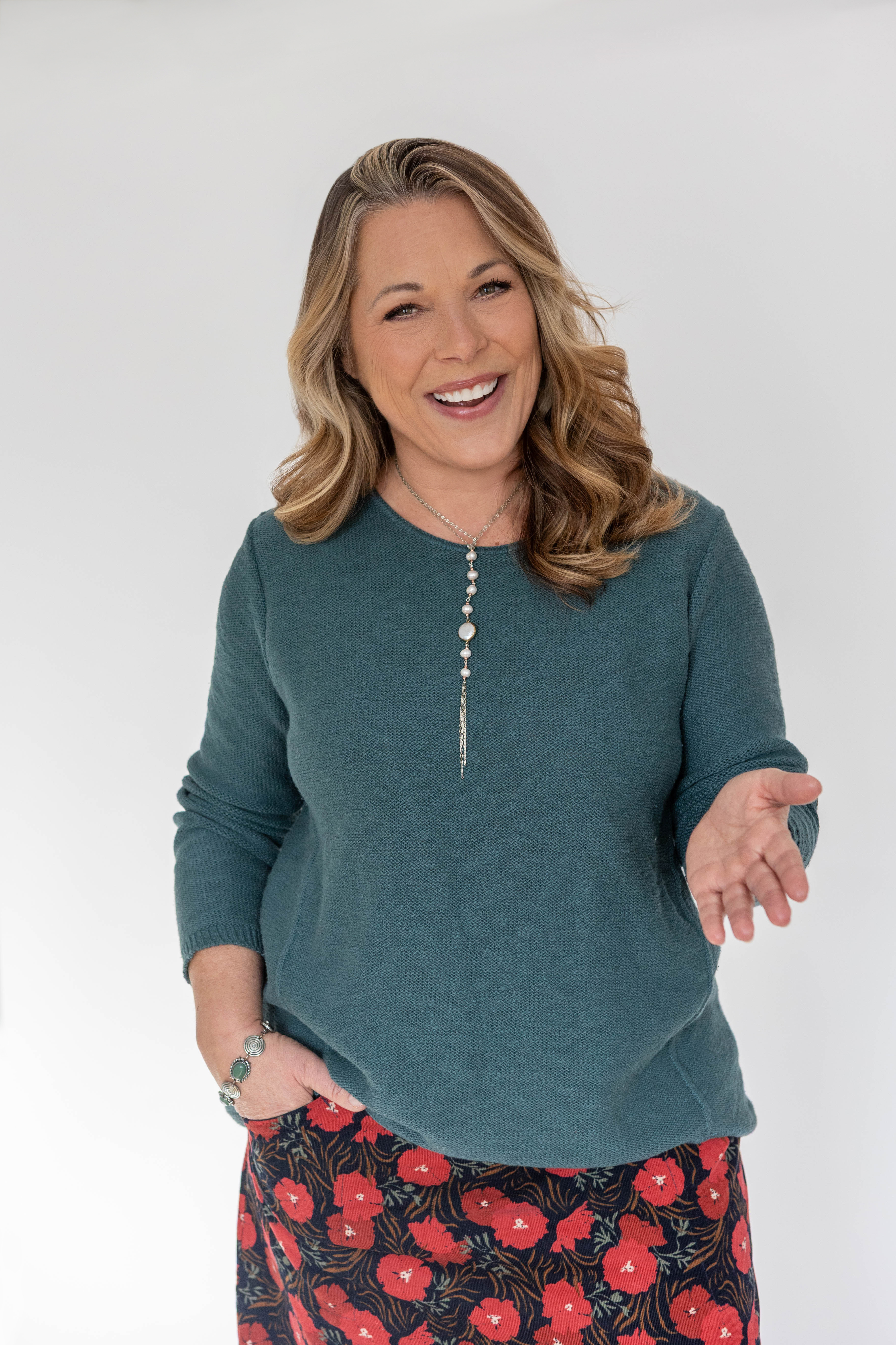 Pasha in a sparkly silver jacket smiling on stage