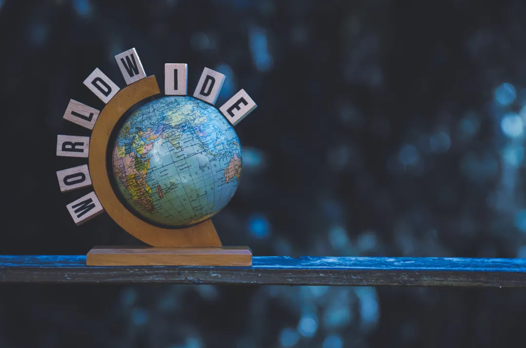 a note with a pen and a flower on a table