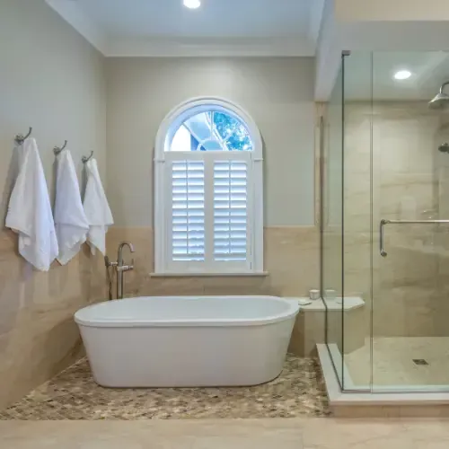 Bathroom remodeling with soaking tub and glass shower enclosure.