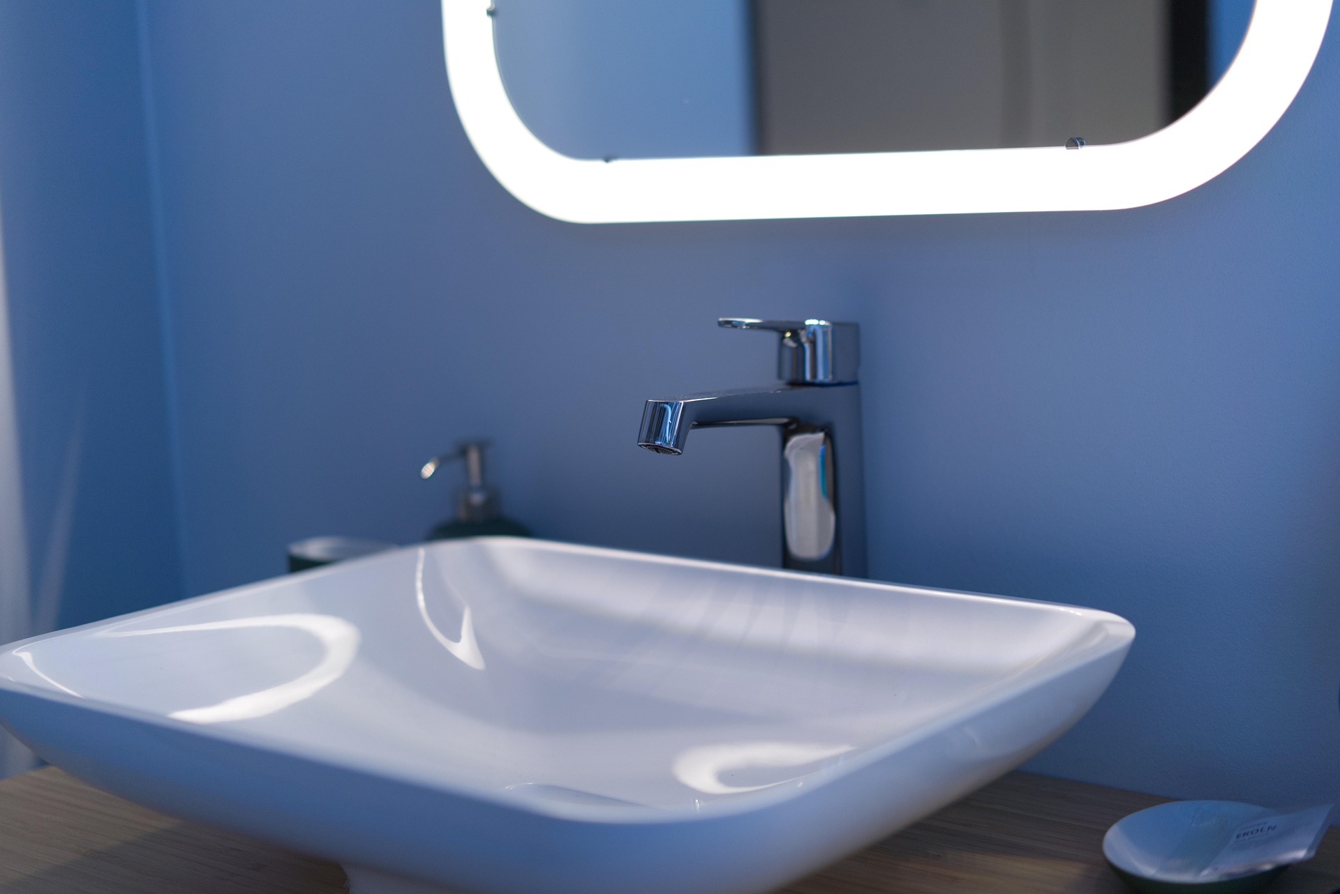 silver sink with silver tap and blue wall behind
