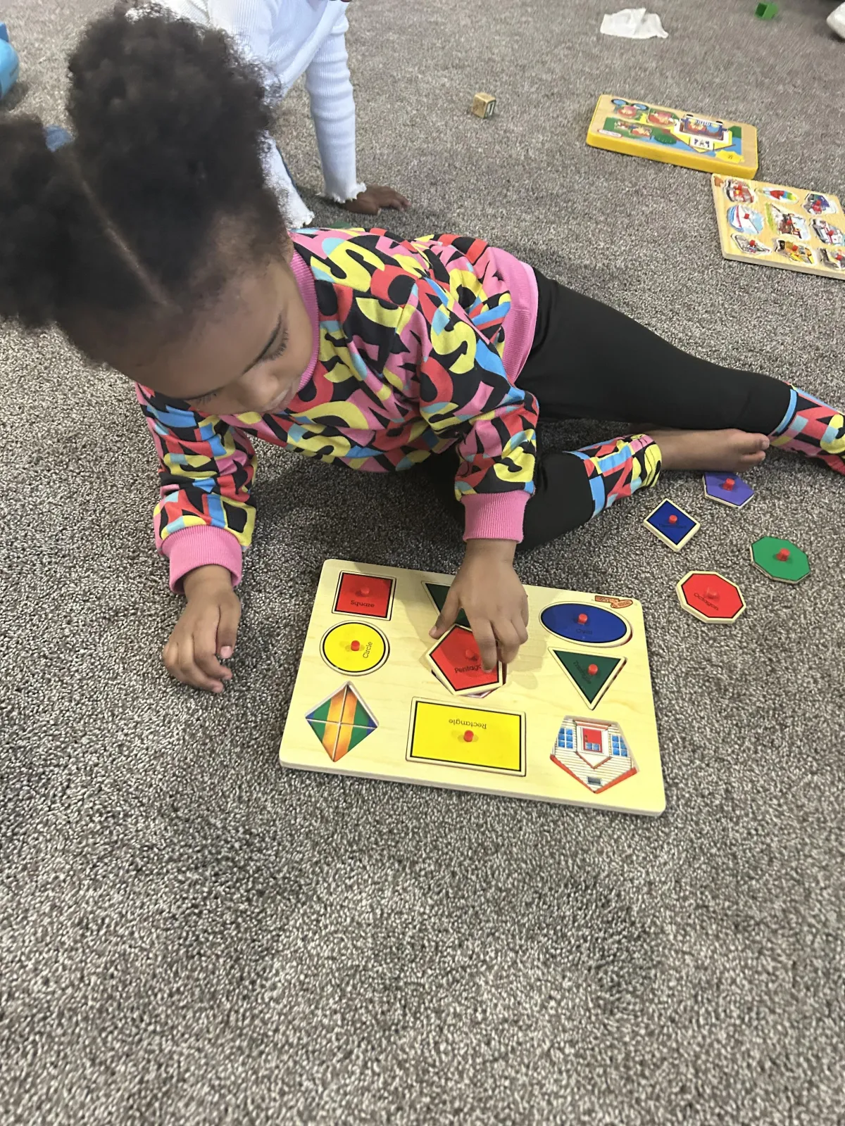 Girl stretches to the side while watching teacher on large screen TV