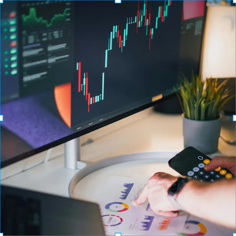 Persona analizando datos financieros y métricas de negocio en un monitor para toma de decisiones estratégicas