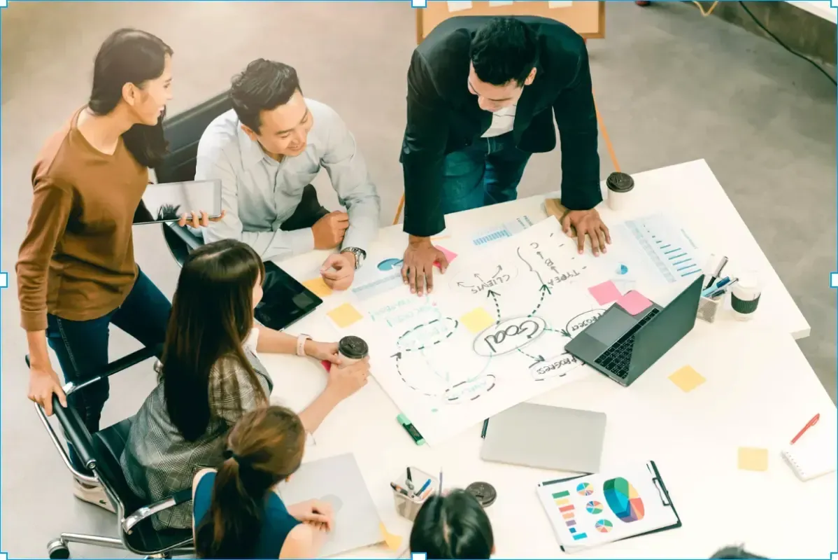 Equipo de profesionales trabajando en la alineación estratégica corporativa analizando gráficas en una junta