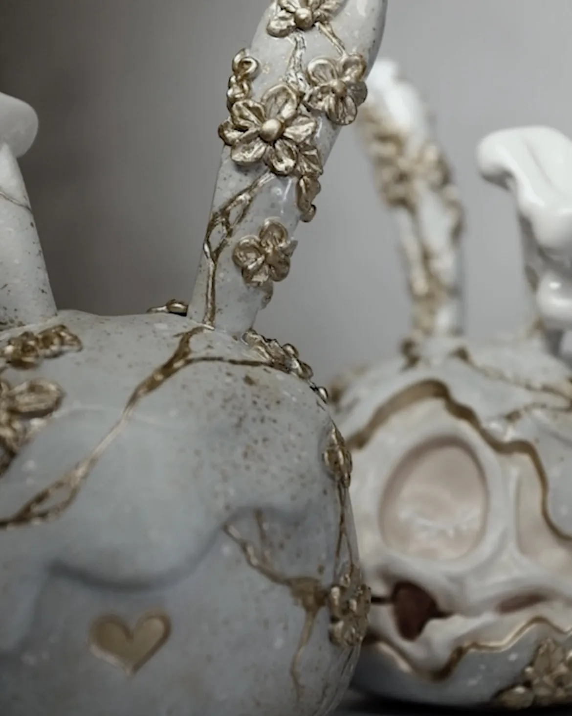 Fable, a custom Goodbunny skull in white on white with gold flowers and drilled cracks