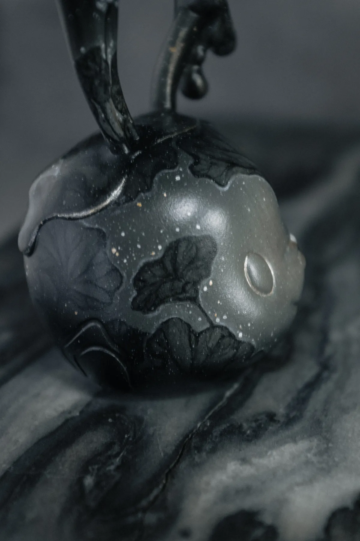 Passage, a custom Goodbunny skull painted black on black with lotus leaves