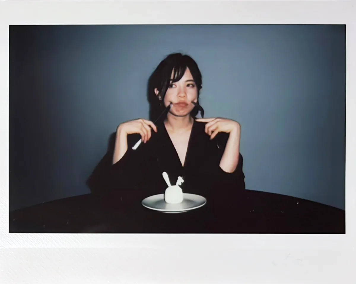 Alice Yuen, the artist behind The Goodbunny Club, holding a knife and fork over a Goodbunny skull on a plate