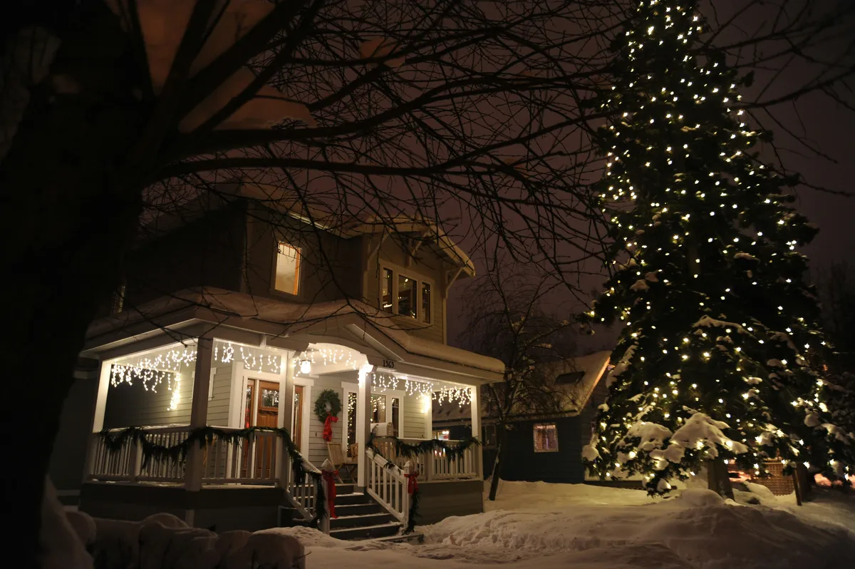 Snowy home with holiday lights at night - selling a Castle Rock home over the holidays - Simon Dzienis, Colorado Realtor