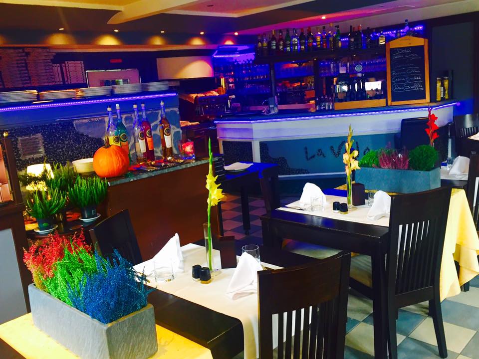 Gemütlicher italienischer Speiseraum mit Holztischen und grünen Akzenten