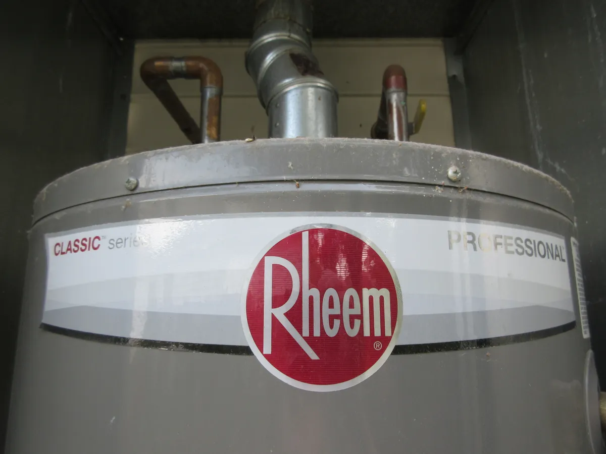 Illustrative detail of a household water heater and its pipes, photographed in 2023