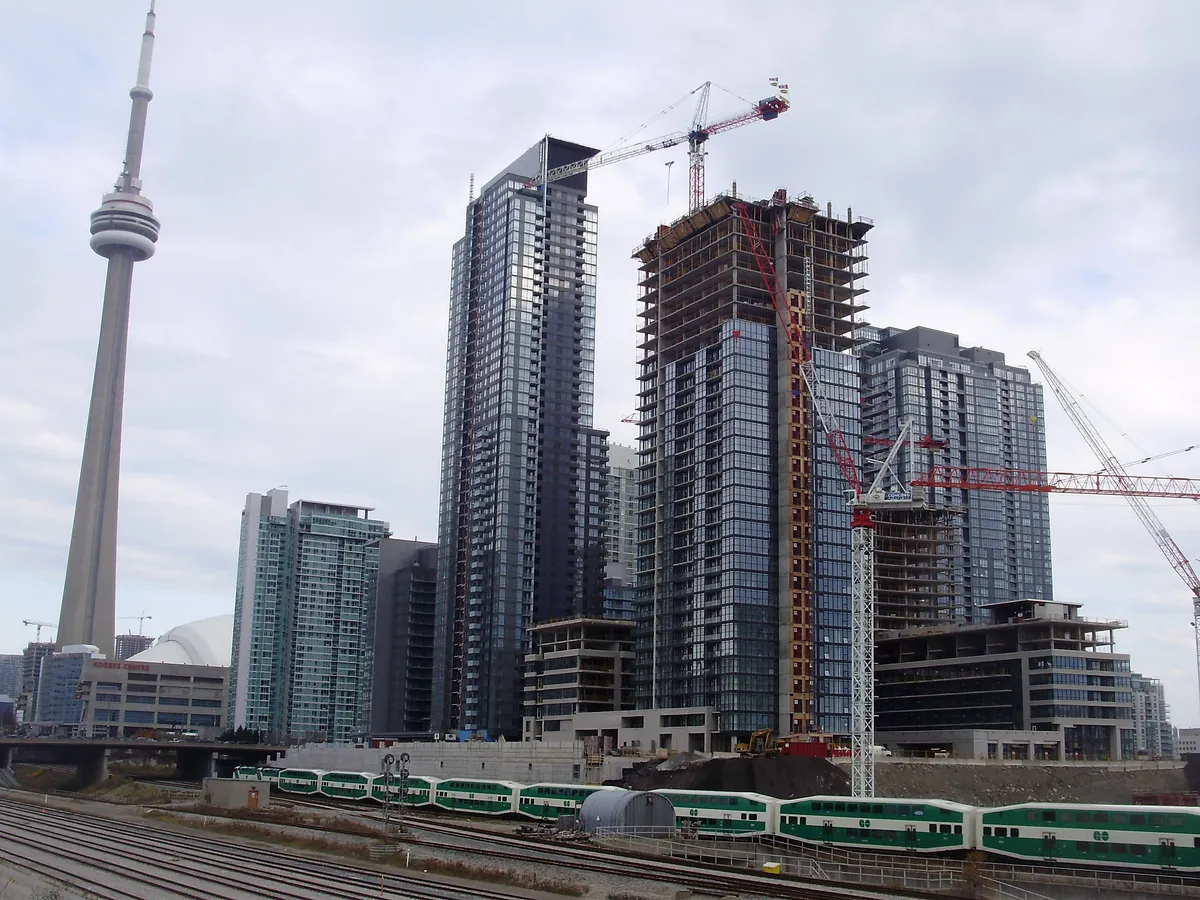 Archive photograph of CityPlace condominium construction in Toronto in November 2008, with the CN Tower and a GO train. Illustrative only.