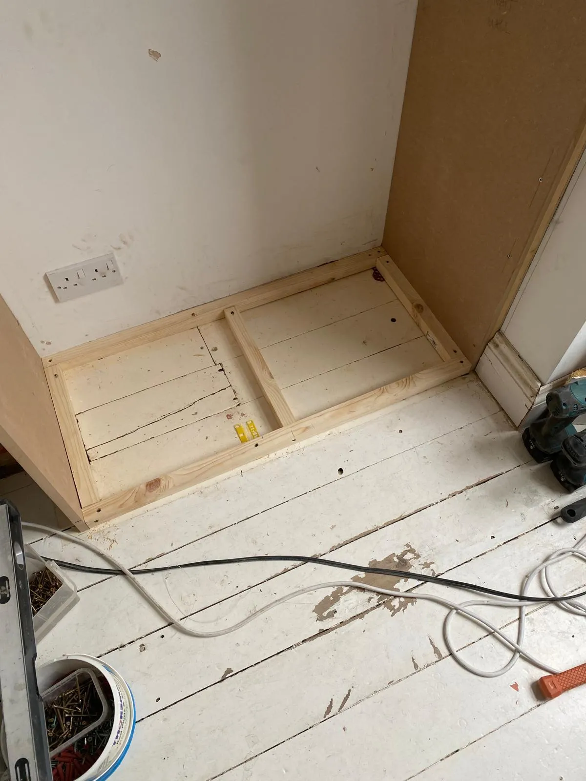 Close-up of the timber floor-frame construction for a bespoke alcove unit, ensuring a level and solid foundation on an older Surrey floor.