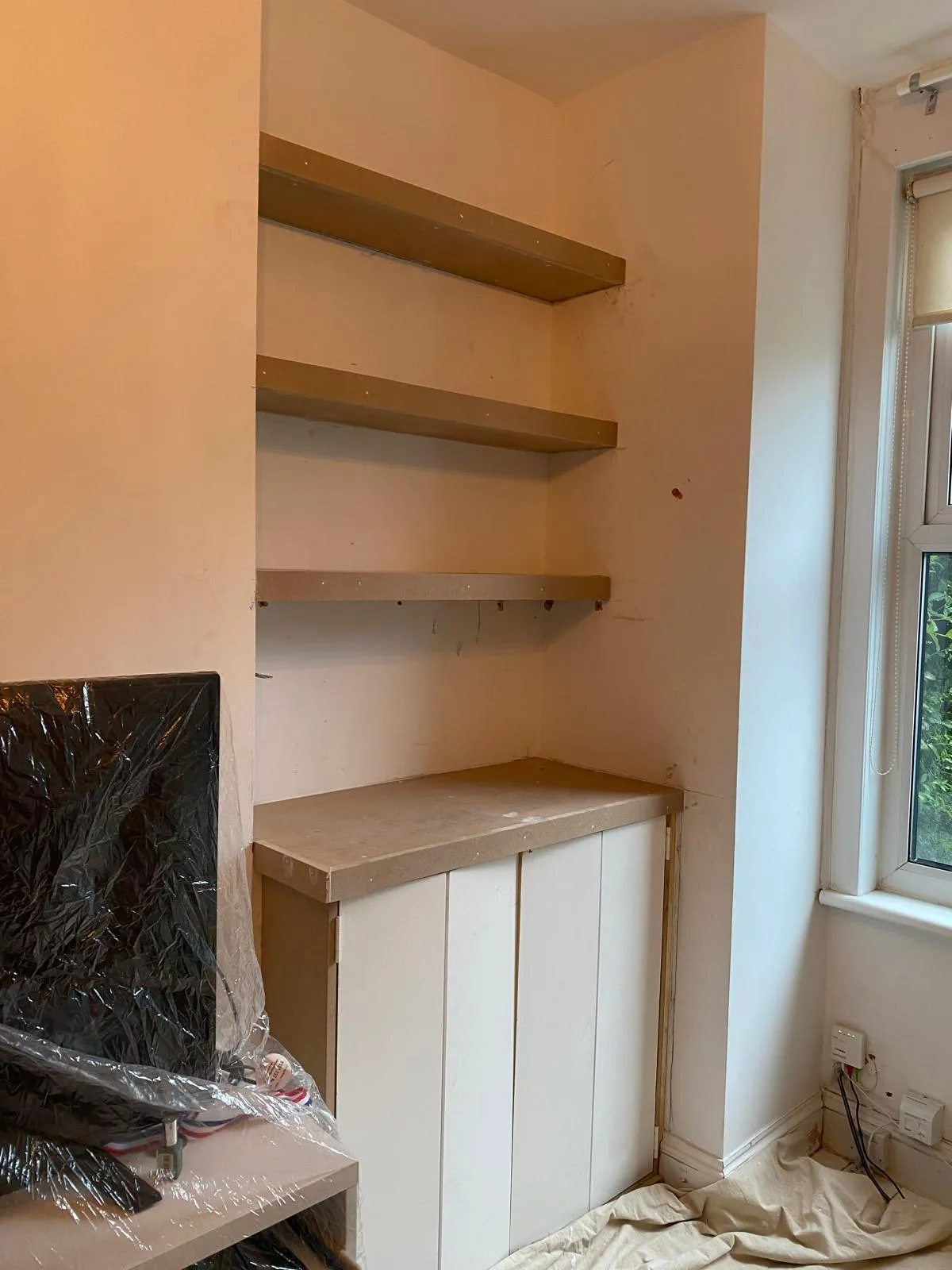 Progress shot of bespoke floating alcove shelves and a custom base unit installed in an Epsom home, ready for final decorating.