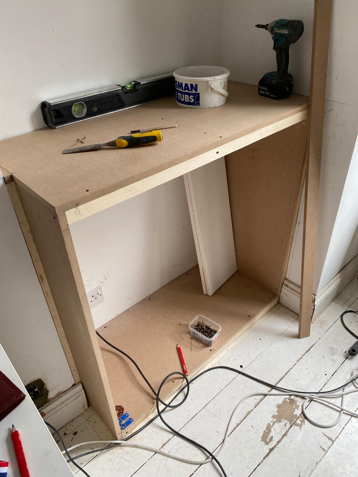 Handyman tools and a spirit level sitting on a newly constructed MDF alcove base unit during a home office storage installation in Epsom.
