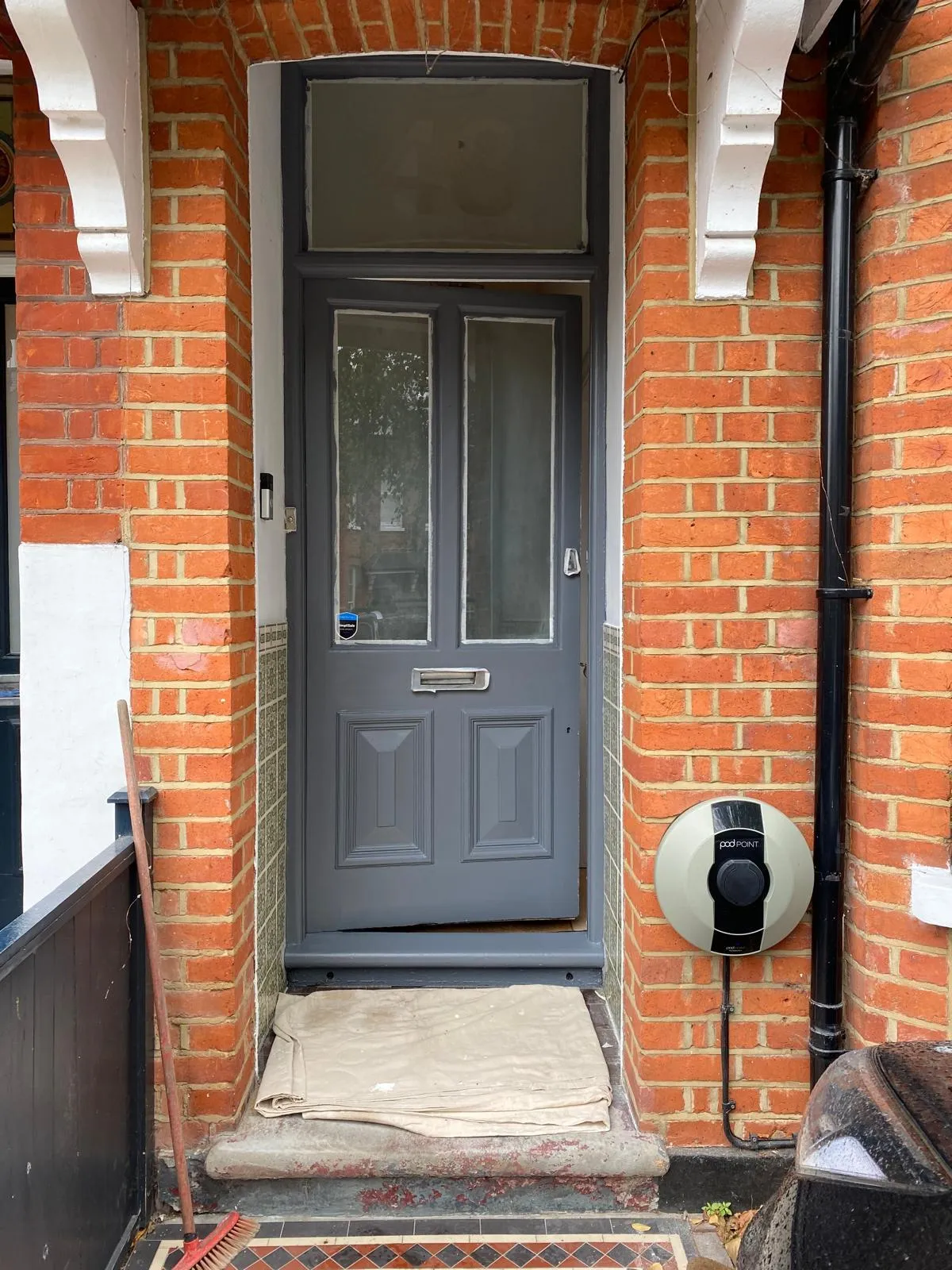 A weathered grey Victorian door in Epsom with flaking paint, prepared for professional timber restoration and a weather-resistant finish.