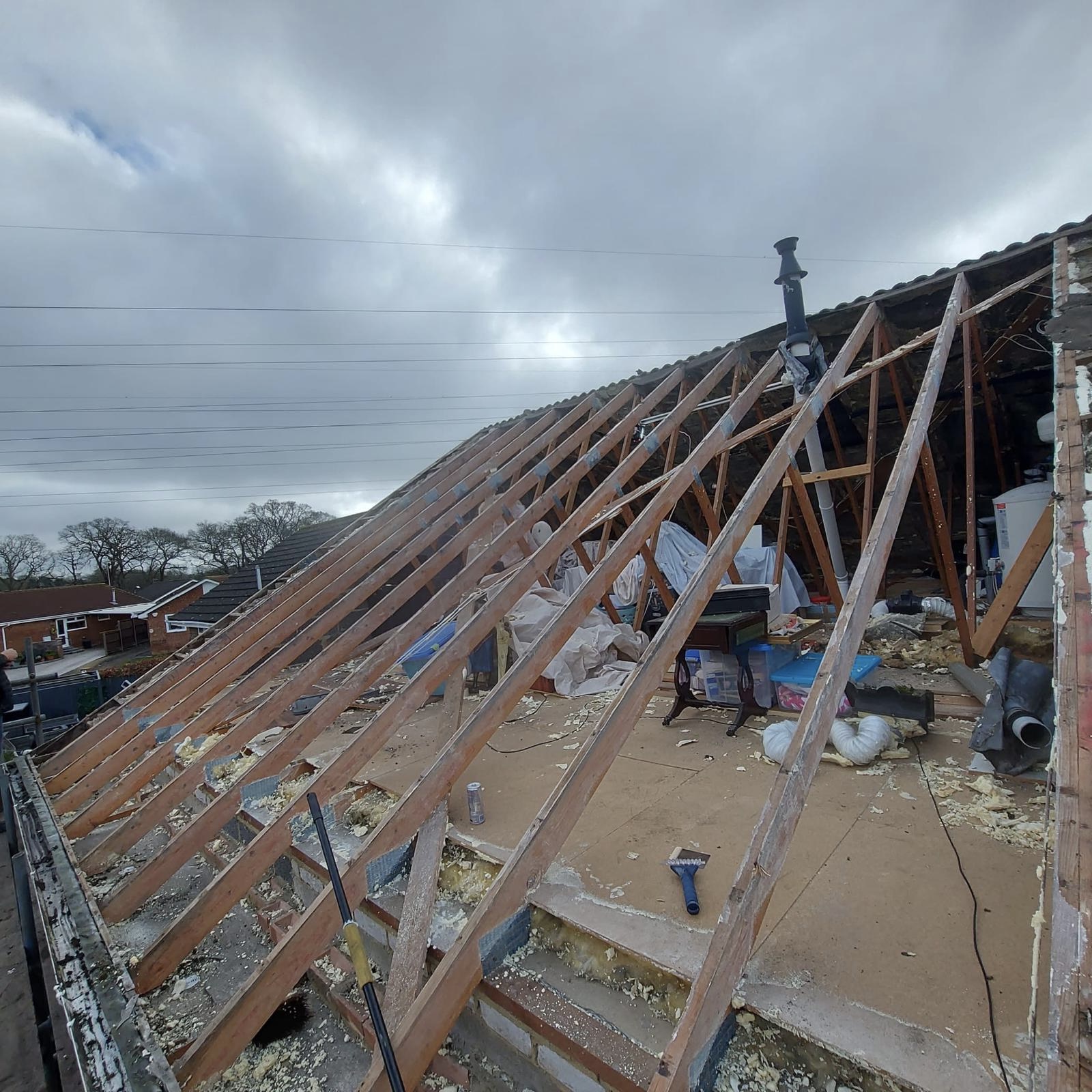 Professional roofer repairing structural timber rafters and framework for a full re-roofing project in Bournemouth, Dorset.