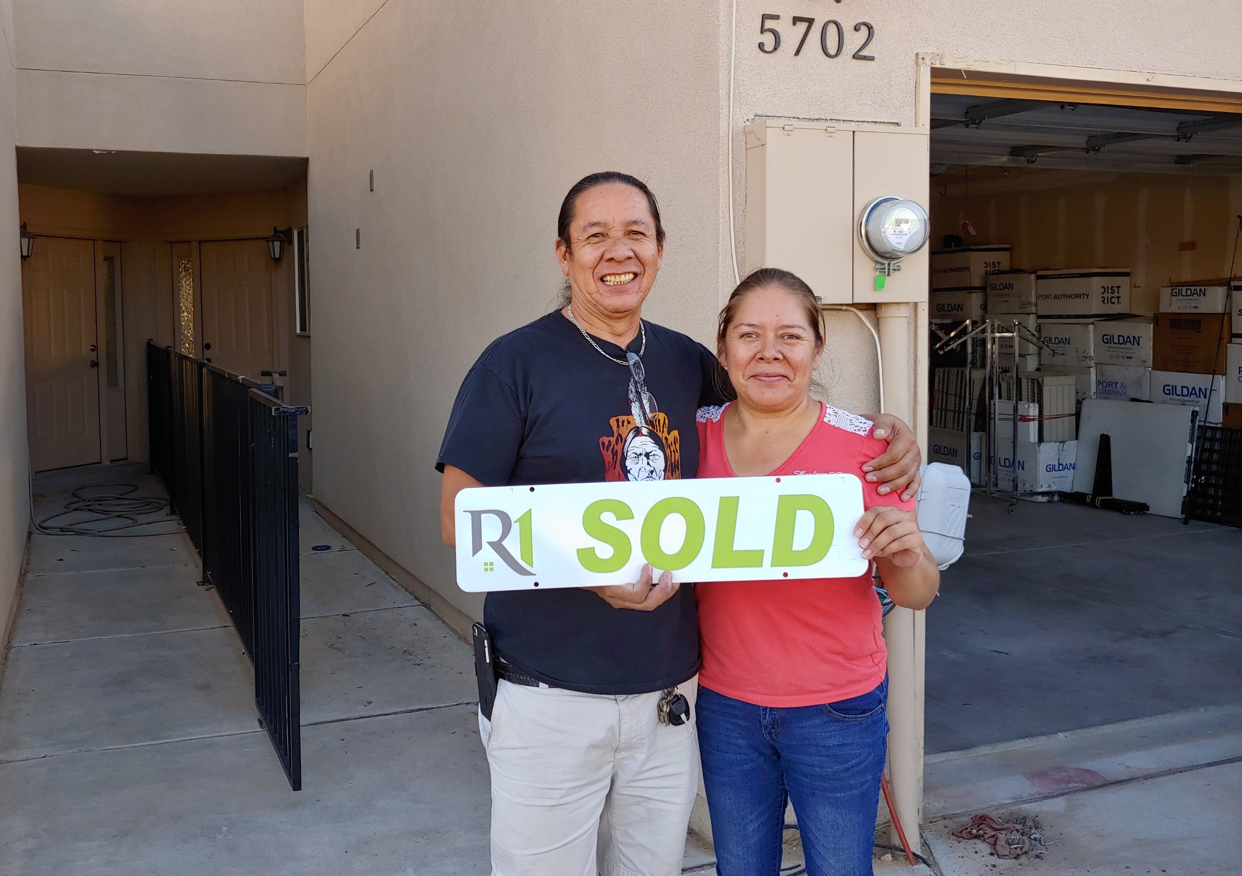 Christensen Properties clients holding a sold sign after selling their Albuquerque home