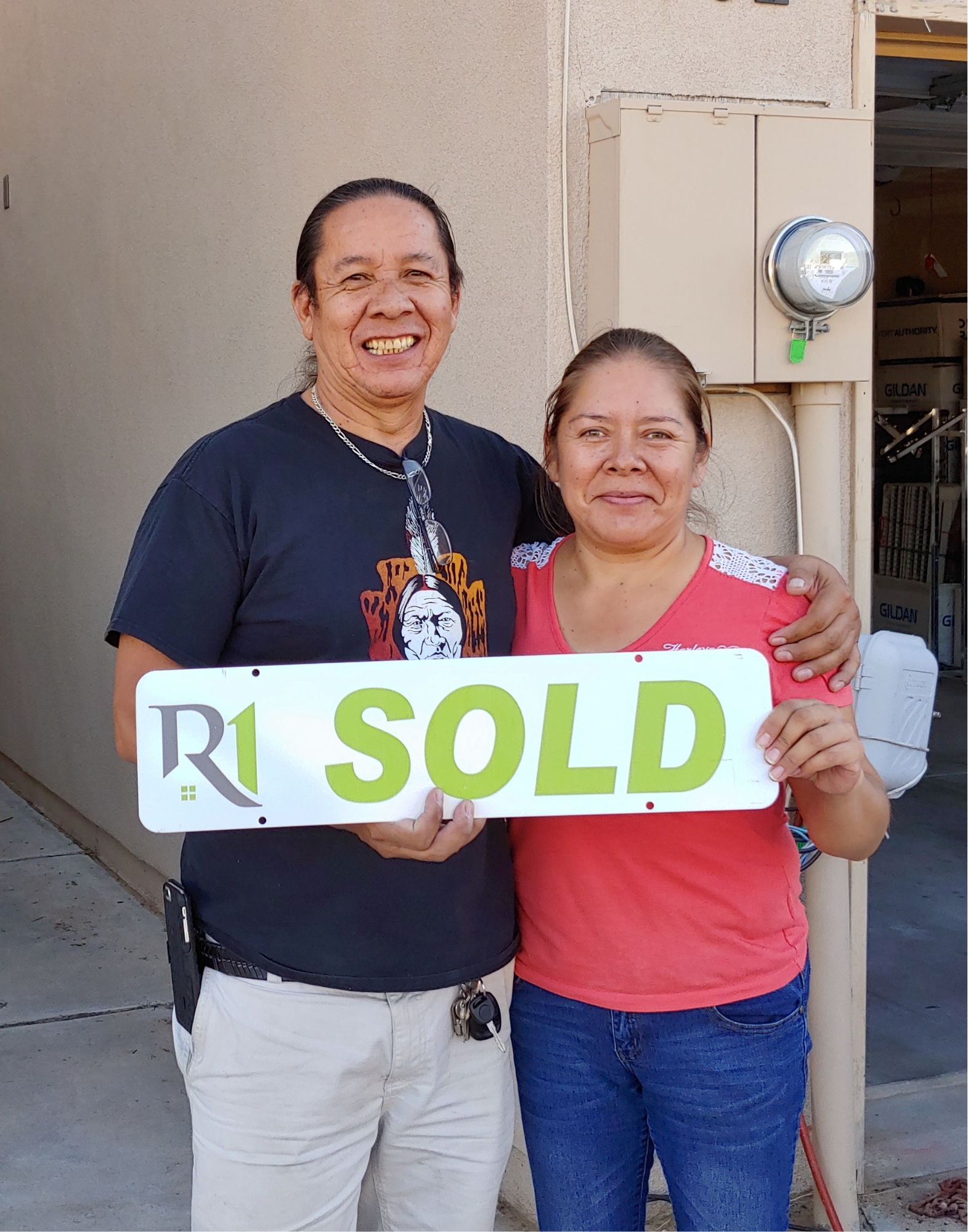 Christensen Properties clients holding a sold sign after selling their Albuquerque home