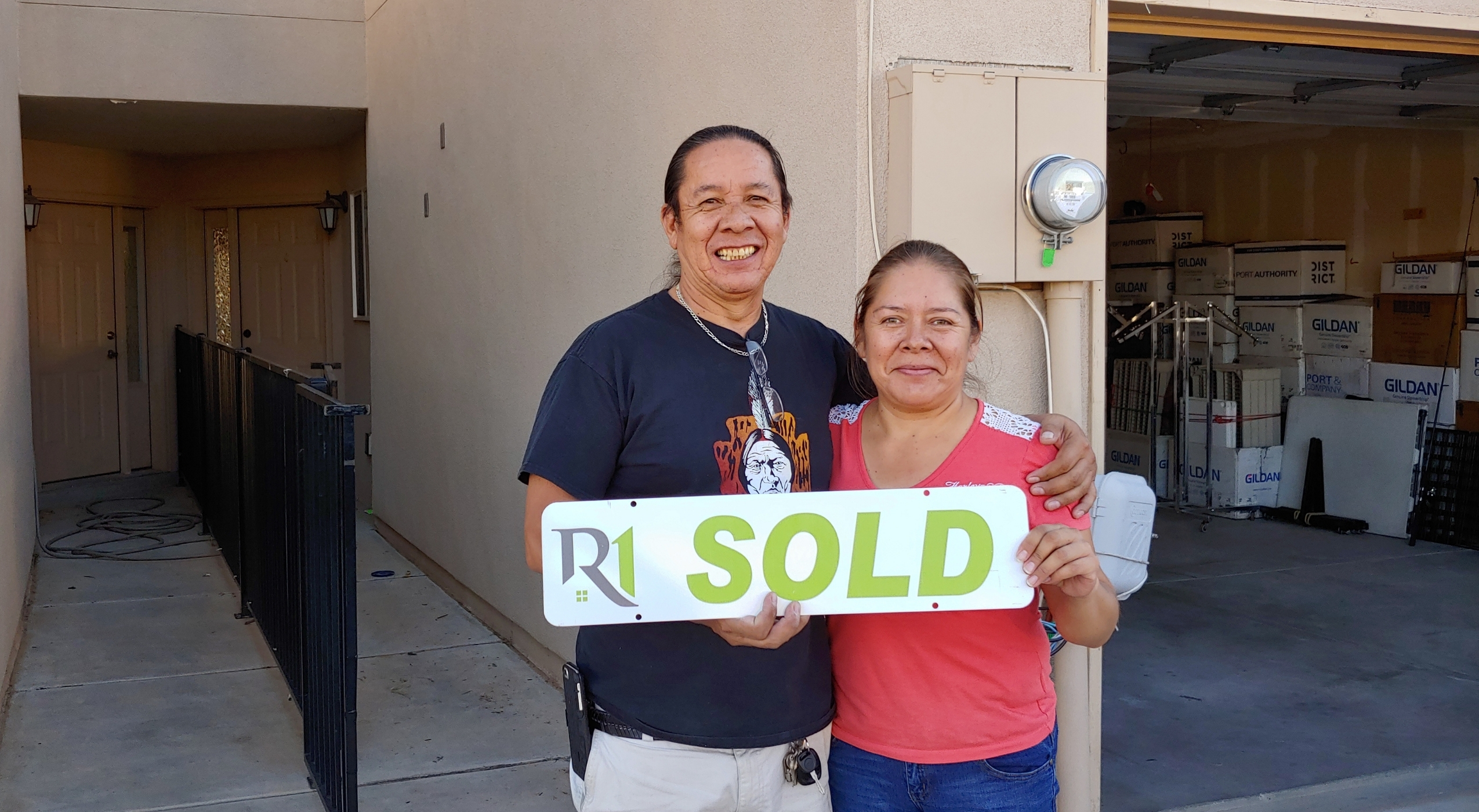 Christensen Properties clients holding a sold sign after selling their Albuquerque home
