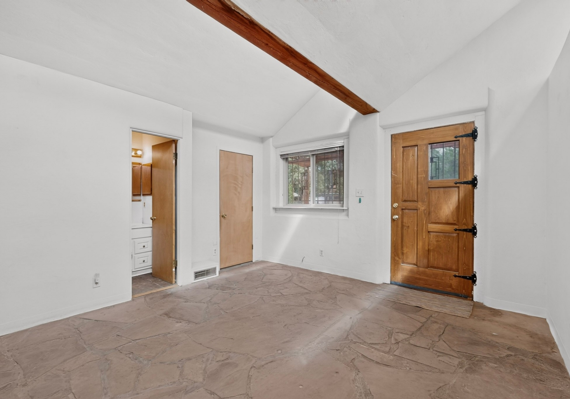 Living room with wood ceiling and stone fireplace at 51 Wolf Trail in Edgewood, New Mexico