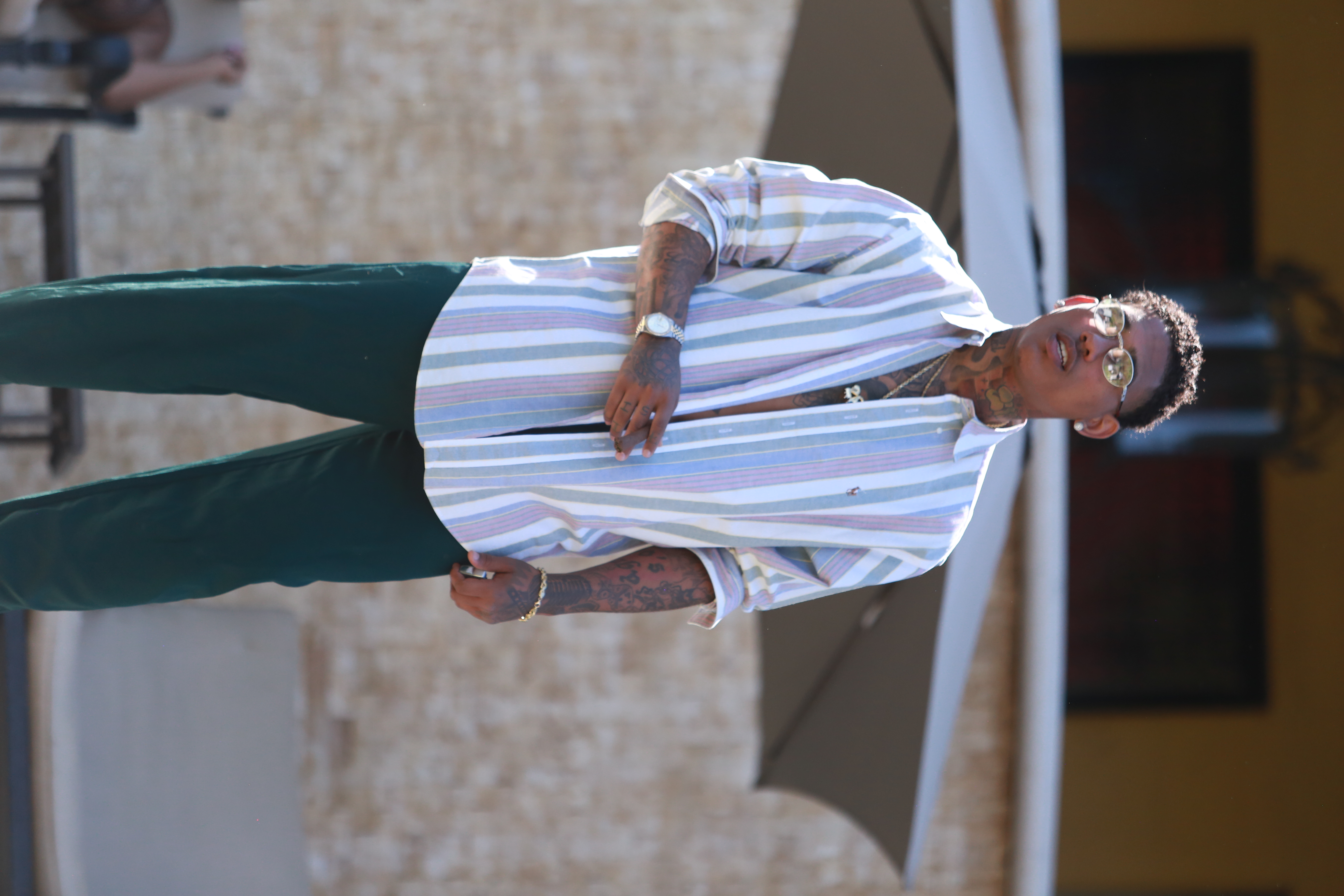 man wearing gray, white, and black polo shirt holding orange pen
