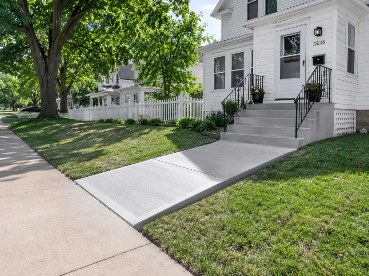 Concrete front walkway and steps at a white home in Racine, WI by GM Concrete