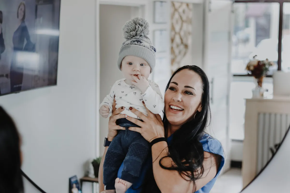 Tiffany hodling a child in her Med Spa