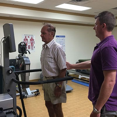 Physical therapist Trevor Gilliam assisting a patient with strength and rehabilitation training at Palm Coast Physical Therapy