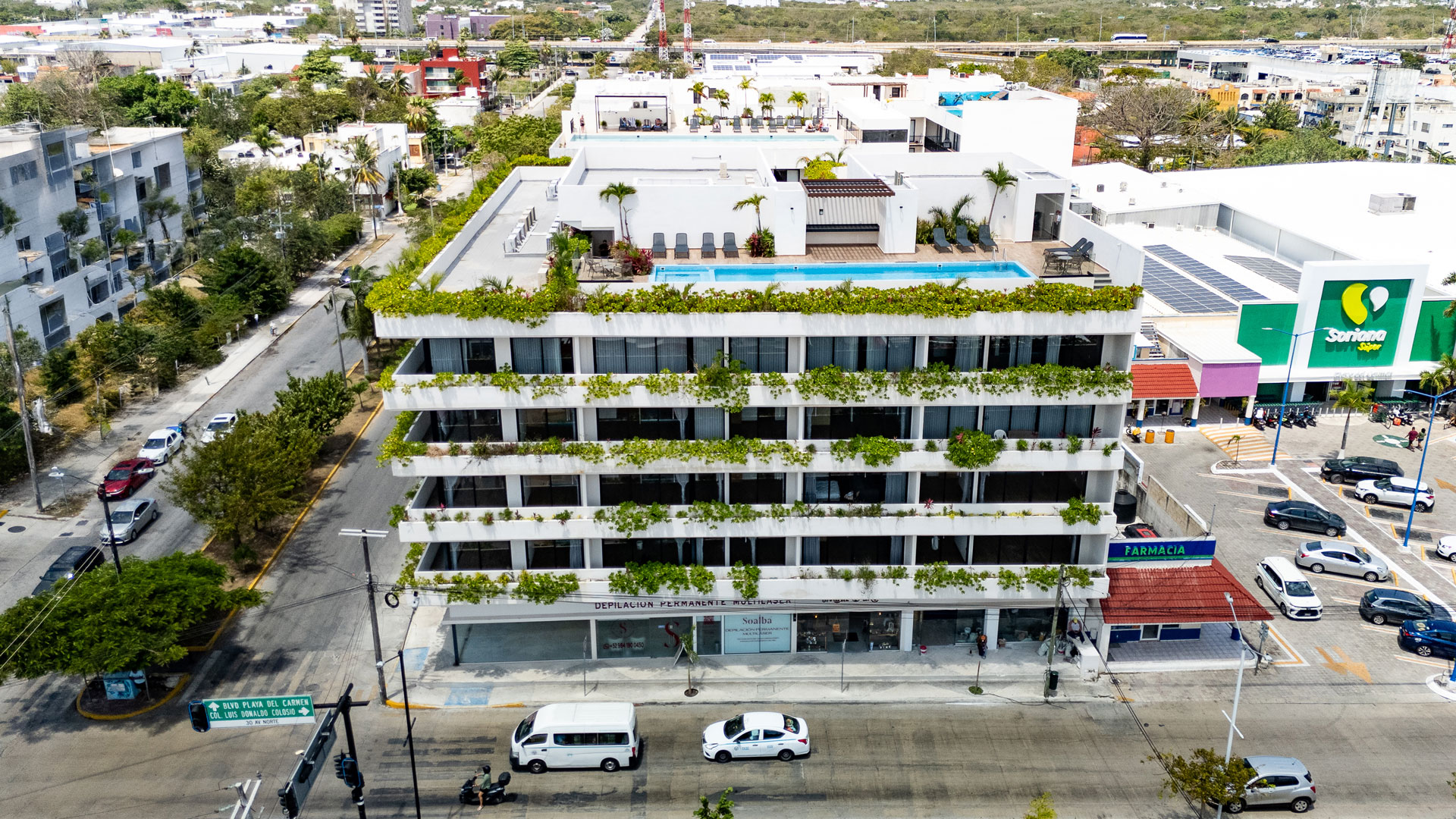 Modern building with glass facade and illuminated storefronts.
