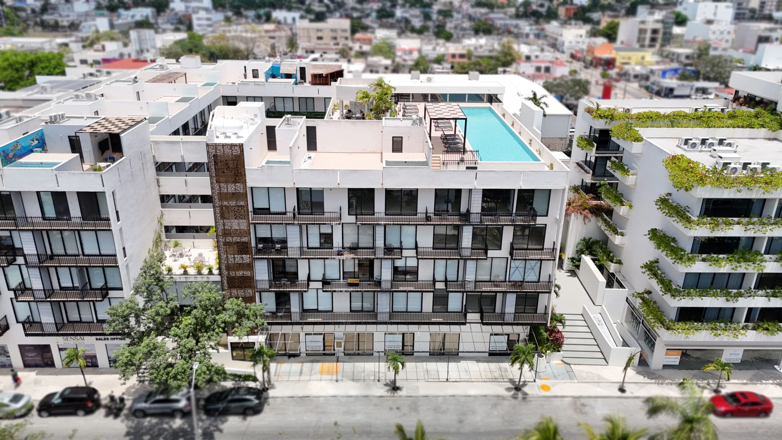 Modern building with glass facade and illuminated storefronts.