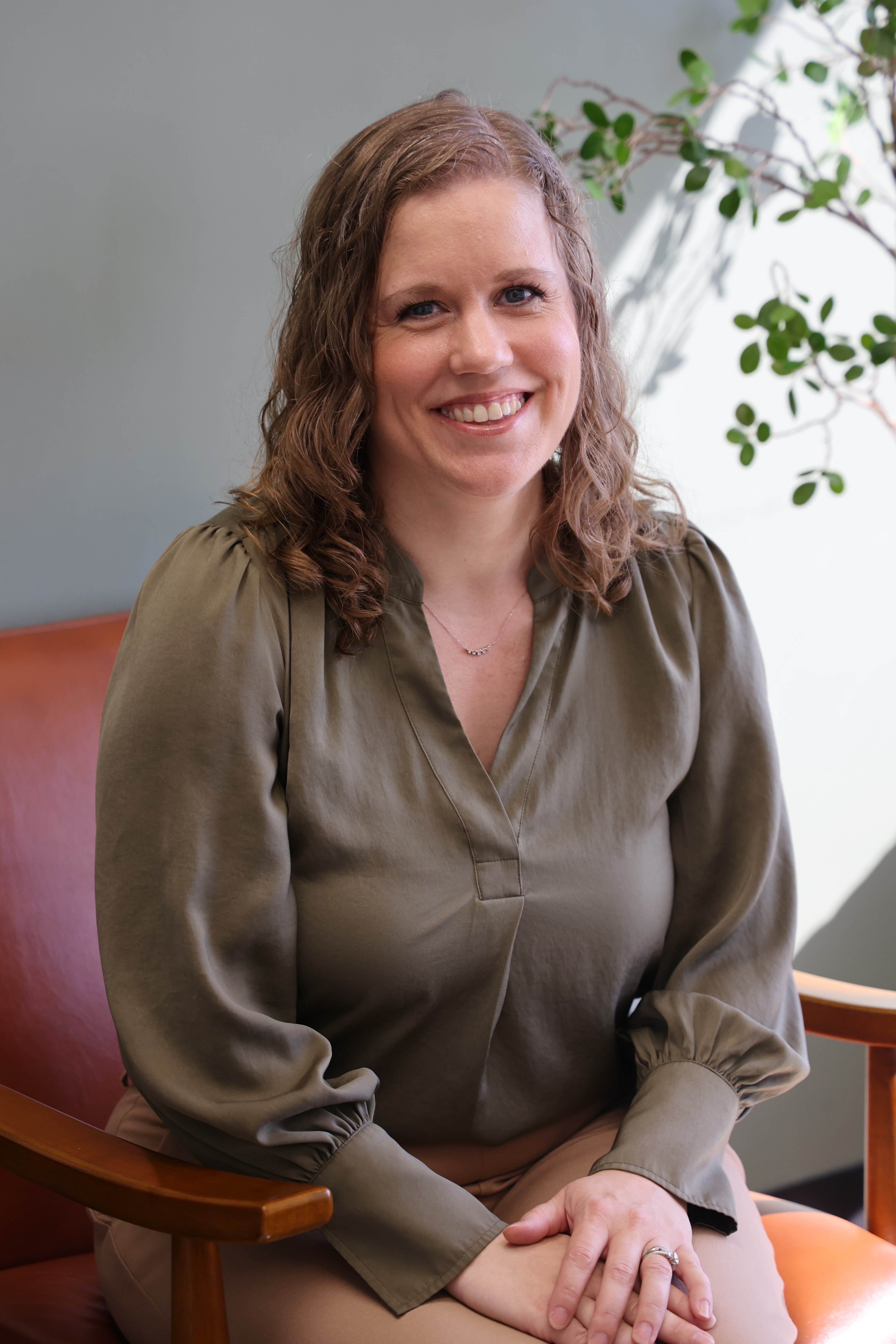 Professional headshot of Dr. Emily Altunay, EMDR and anxiety therapist, in a green blouse