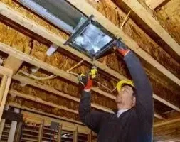 A man is installing or repairing a ceiling in a residential home.