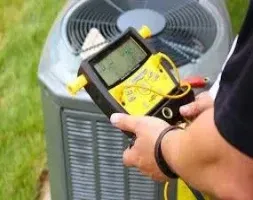 A man checks the air conditioner's temperature with a digital thermometer, focusing on accurate readings.