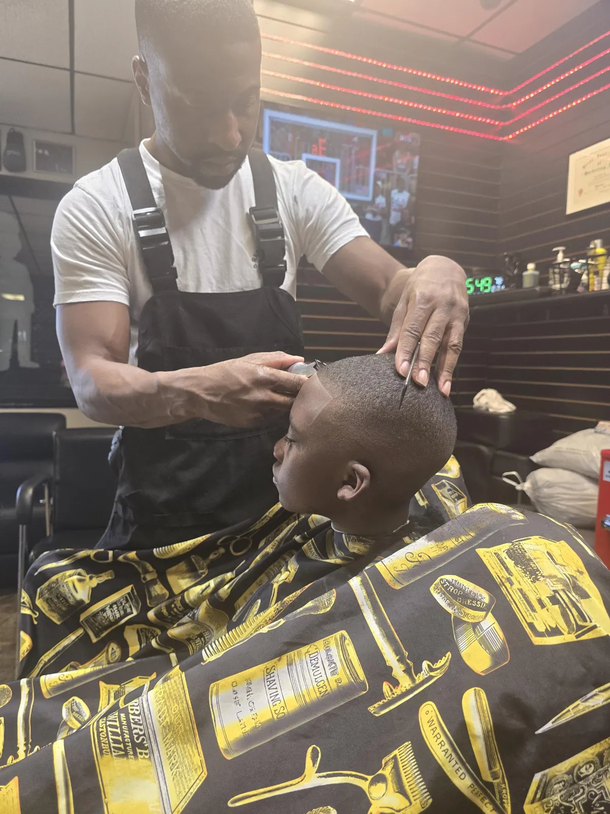 greyscale photo of boy having a haircut