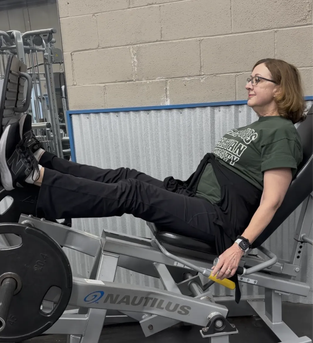 Coach guiding a client through a loaded strength exercise at a private studio in Northbrook, IL