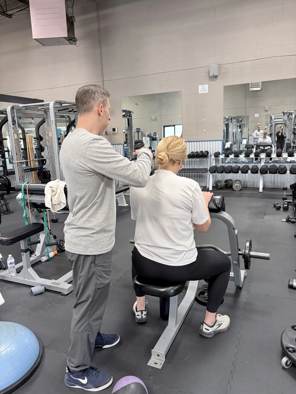 Coach guiding a client through a supported strength exercise at a private studio in Northbrook, IL