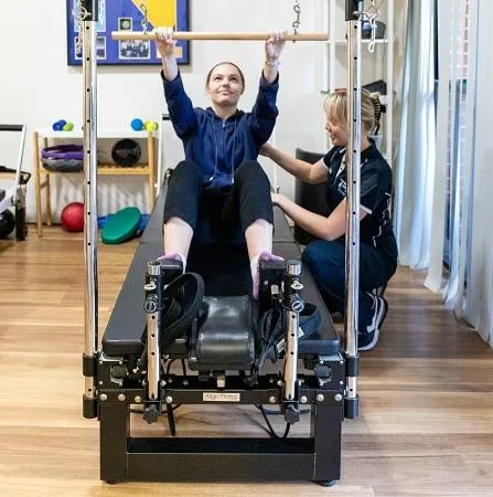 Physio supervising client doing pilates