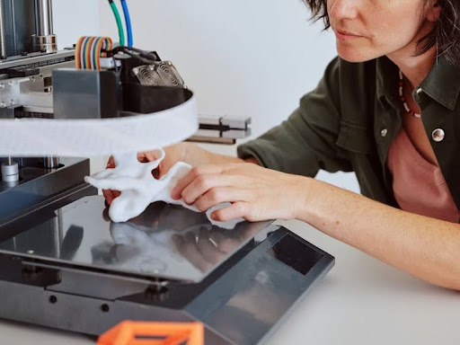 A tech professional building a prototype using a 3D machine.
